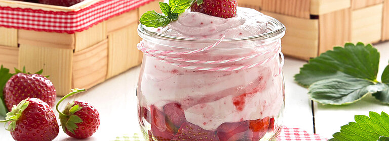 Erdbeer-Quark-Dessert im Glas und Körbchen mit Erdbeeren