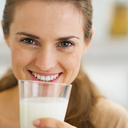 Eine blonde Frau mit einem Glas Milch